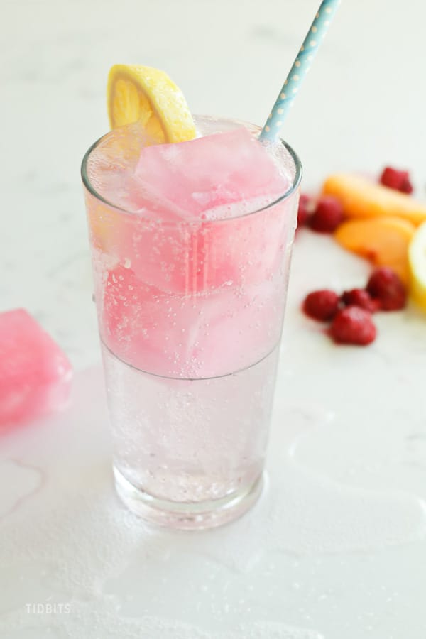 A glass of fizzy drink on a white surface