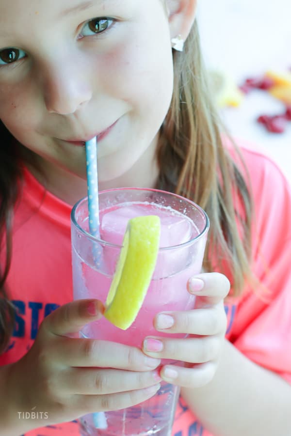 A girl drinking fizzy drink from a straw