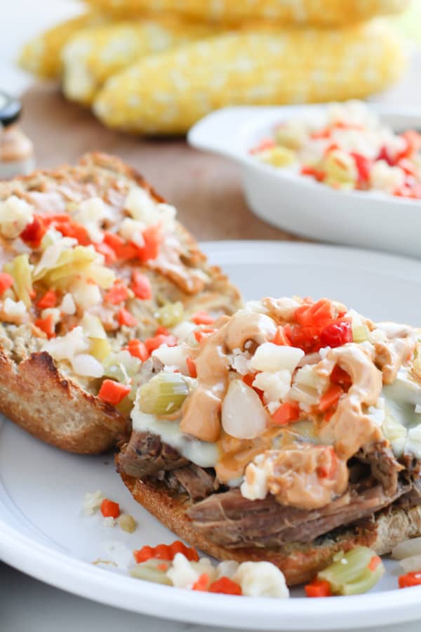 An open pepperoncini beef sandwich with pickle
