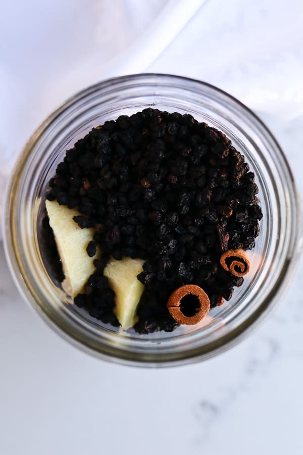 Top shot of Pressure Cooker Elderberry Juice in a mason jar with additional ingredients