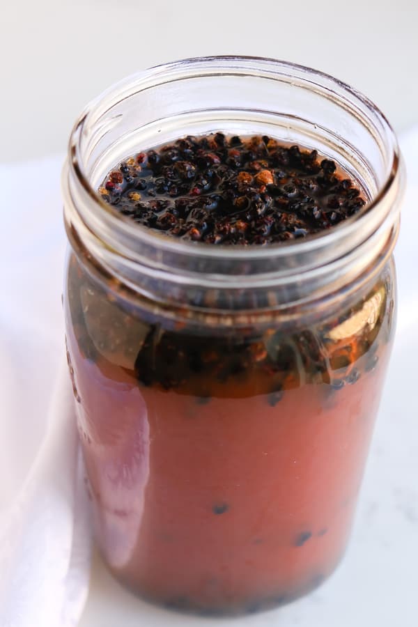Pressure Cooker Elderberry Juice in a mason jar on white background