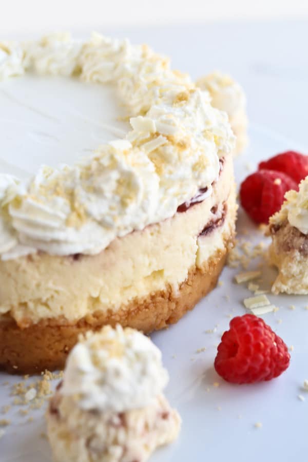 Close up of a Pressure Cooker White Chocolate Raspberry Cheesecake with fresh fruit