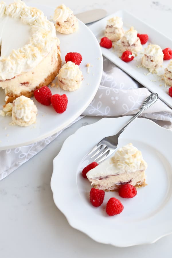 A slice of Pressure Cooker White Chocolate Raspberry Cheesecake on a serving plate