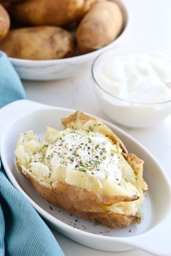 Instant Pot Baked Potato on a dish with sour cream and butter