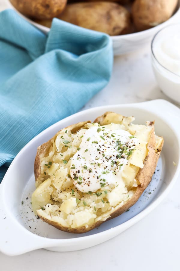 Instant Pot Baked Potato on a dish with sour cream and butter