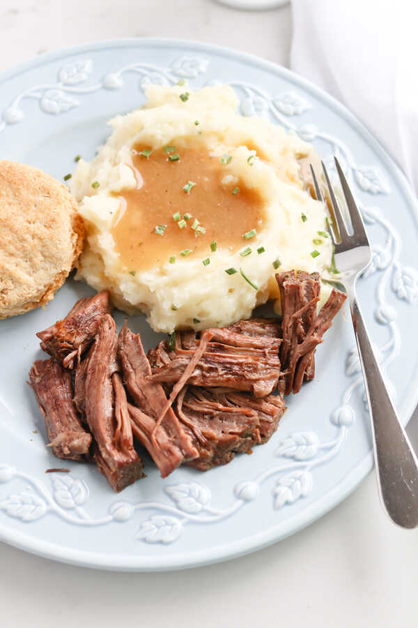 Instant Pot Pot Roast on plate with mashed potato and biscuit