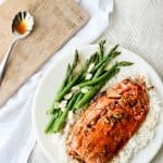 Top shot of Teriyaki Salmon on a white plate served with greens