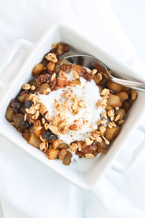 apple fig compote in a white bowl with cream