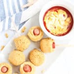 Corn dog muffins on a white platter with ketchup and mustard dip
