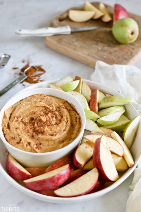 pumpkin dip in a white bowl with apples and pears
