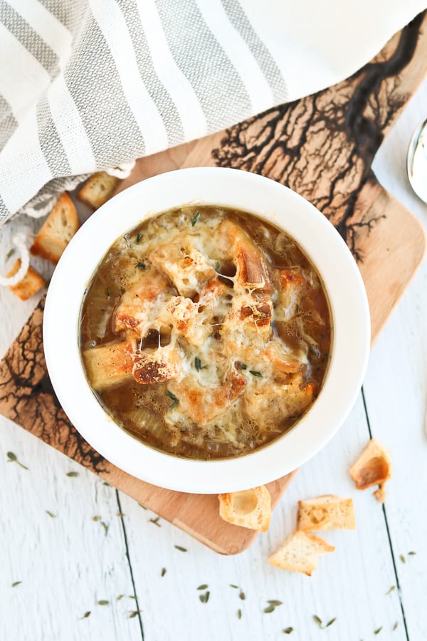 french onion soup in a white bowl with cheese melted on top