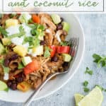 jerk chicken in a bowl topped with tomatoes, yogurt, and avocados