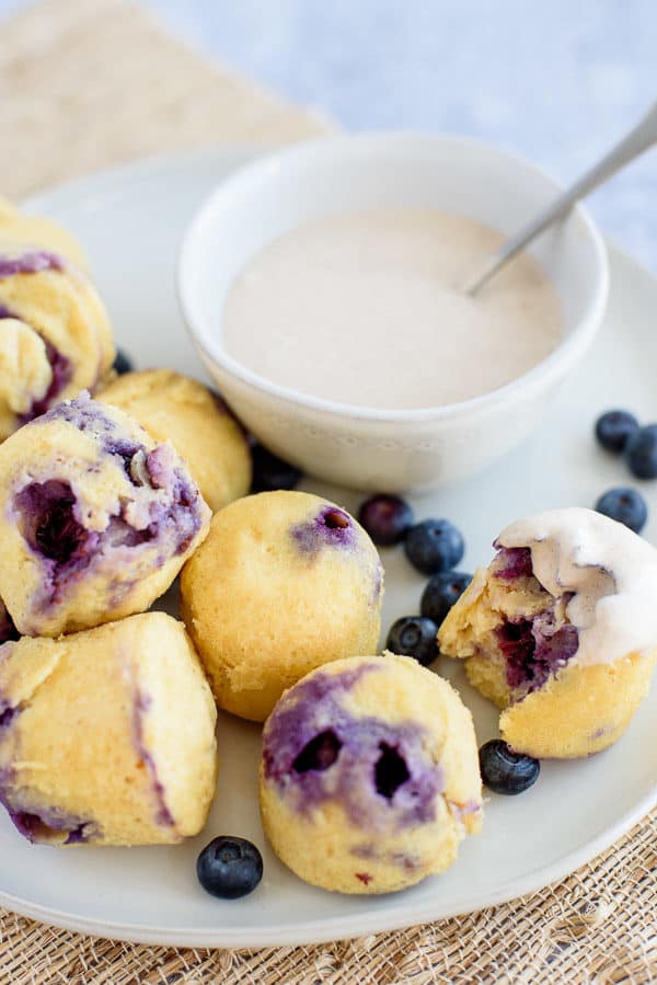 Blueberry breakast cakes on a white plate with creamy dip