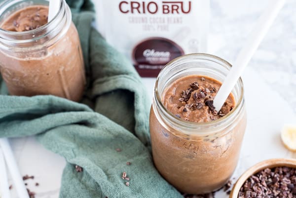 Crio Bru Smoothie in a mason jar with a white straw and cacao nibs