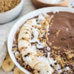 Crio Bru Smoothie in a white bowl with bananas, coconut, and granola
