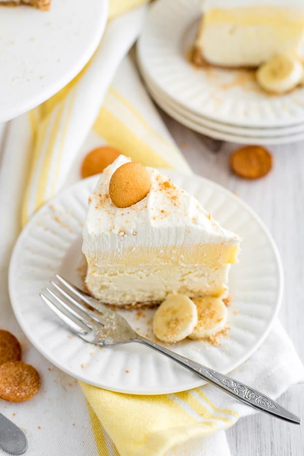 slice of Banana cream pie cheesecake on a white plate with yellow napkins