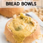 Bread bowl with broccoli cheese soup on a white plate