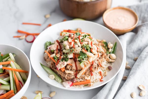 Instant Pot Bahn Mi in a white bowl with carrots and cilantro with creamy saauce