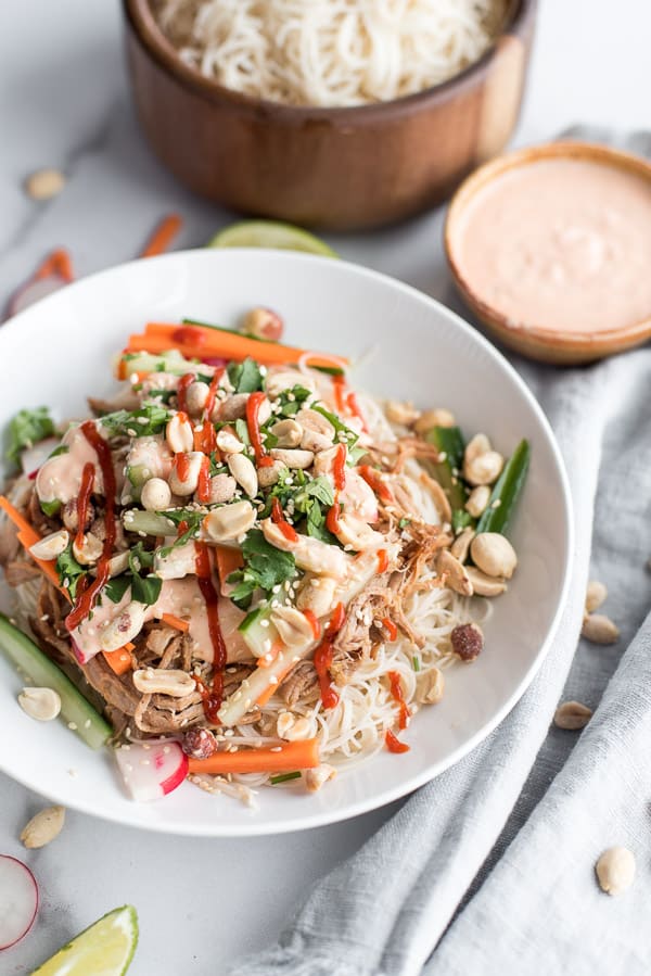 Instant Pot Bahn Mi in a white bowl with carrots and cilantro with creamy sauce