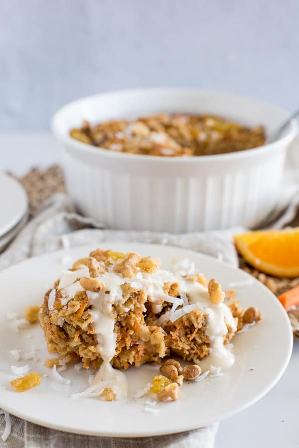 Instant Pot Carrot Cake Oatmeal on a white plate with white yogurt sauce over top
