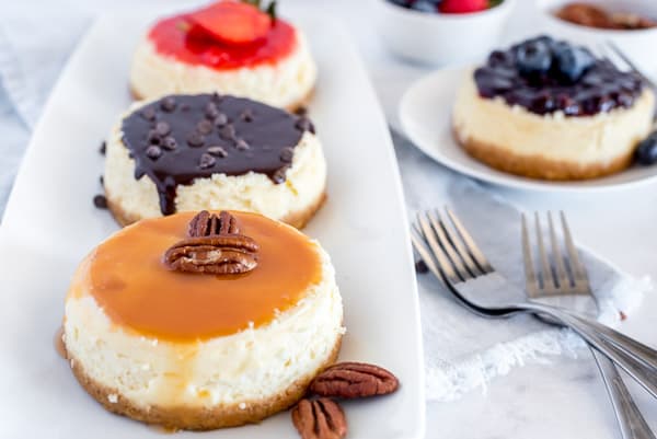 mini cheesecakes with chocolate, caramel pecan and strawberry toppings