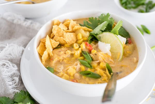 southwest chicken corn chowder in a white bowl garnished with cilantro and tortilla chips